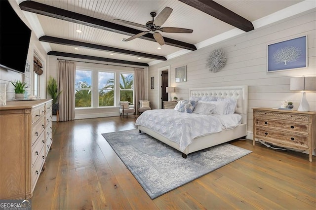 bedroom with beamed ceiling and hardwood / wood-style floors