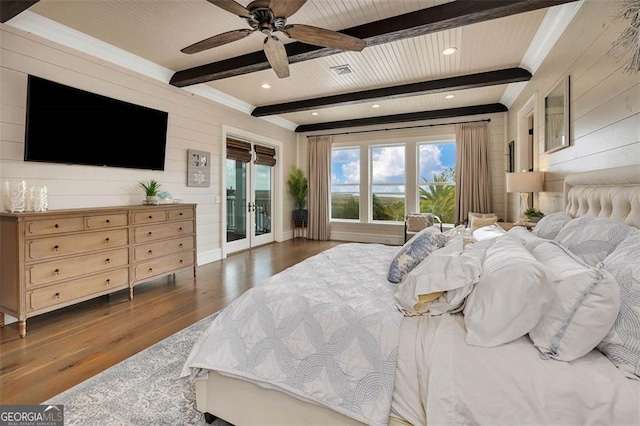 bedroom with access to exterior, beam ceiling, wooden walls, and wood finished floors