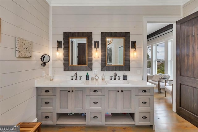 full bathroom featuring double vanity, a sink, and wood finished floors