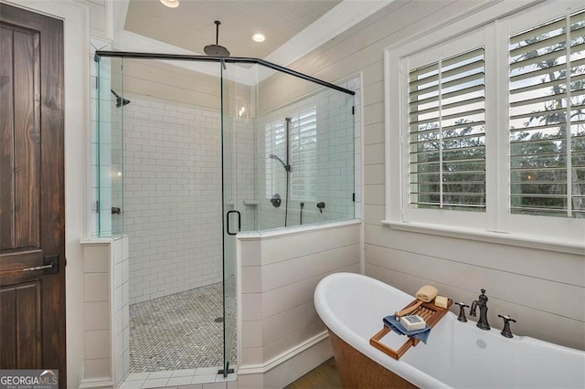 full bathroom with a stall shower and a freestanding bath