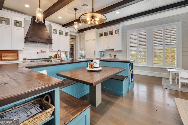 kitchen featuring dark wood-style floors, premium range hood, and white cabinetry