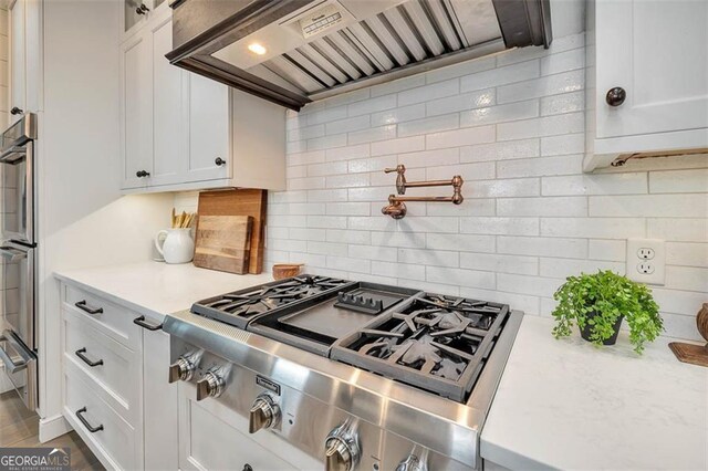 174 Bartram Way, Waverly, GA 31565 - kitchen featuring premium range hood, white cabinets, appliances with stainless steel finishes, and tasteful backsplash