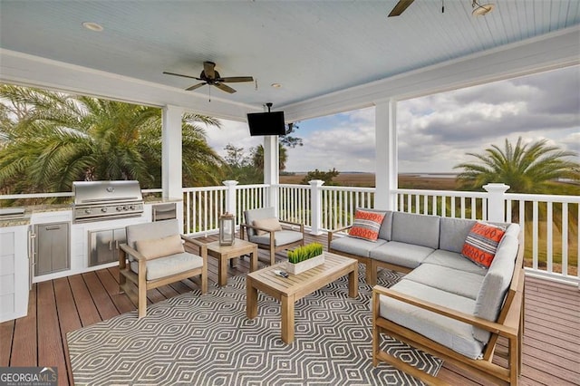 wooden deck with ceiling fan, exterior kitchen, a grill, and an outdoor living space