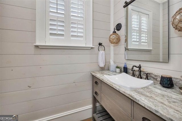 bathroom with wood walls and vanity