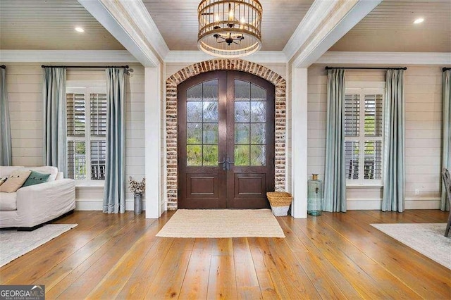 entrance foyer featuring plenty of natural light, french doors, crown molding, and hardwood / wood-style floors