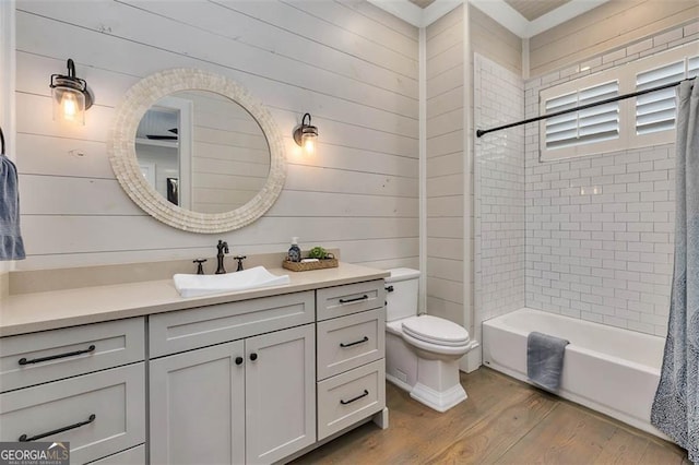 full bath featuring toilet, wood finished floors, vanity, wood walls, and shower / bathing tub combination