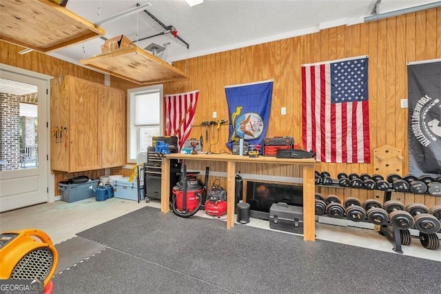 garage with wooden walls and a workshop area