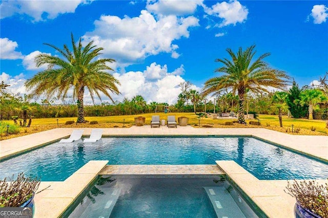 view of pool with a pool with connected hot tub and a patio