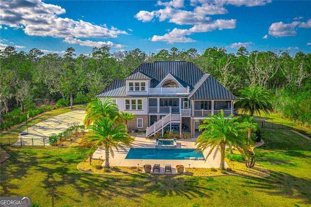 rear view of house with a patio, a lawn, a standing seam roof, fence, and stairs