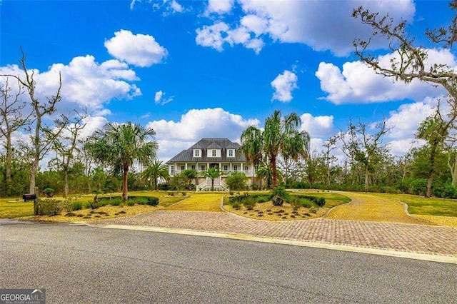 view of front of home with a front yard and decorative driveway