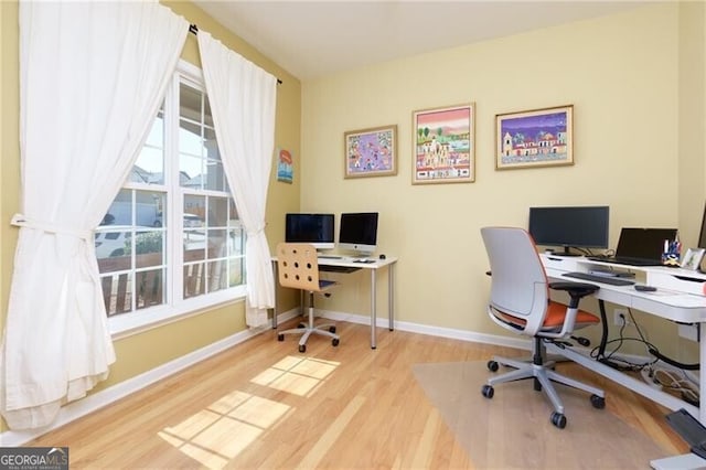 home office with baseboards and light wood-style floors