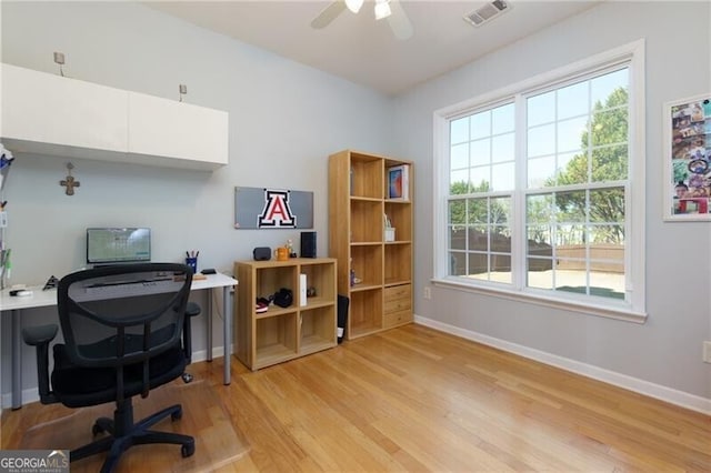 office featuring light wood-type flooring, baseboards, visible vents, and a ceiling fan