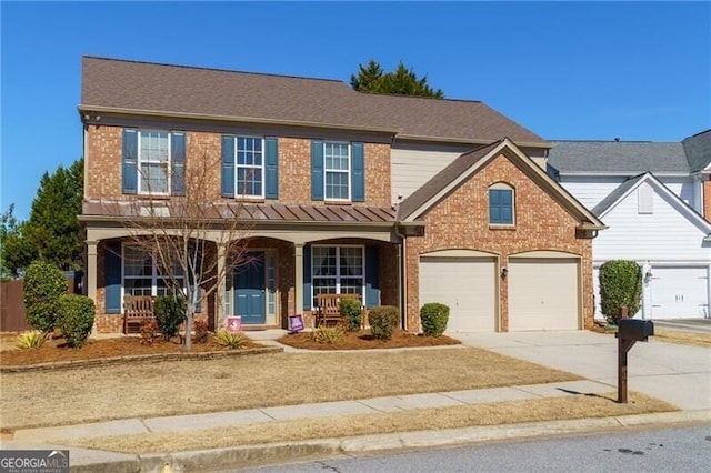 traditional-style house featuring a garage, covered porch, brick siding, and concrete driveway