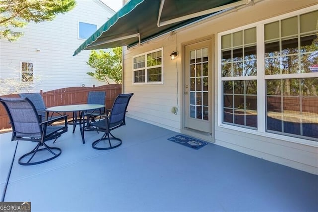 view of patio with fence and outdoor dining space