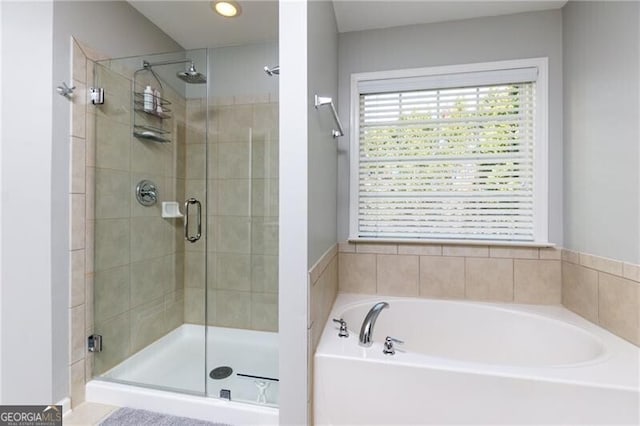 full bathroom featuring a shower stall and a bath