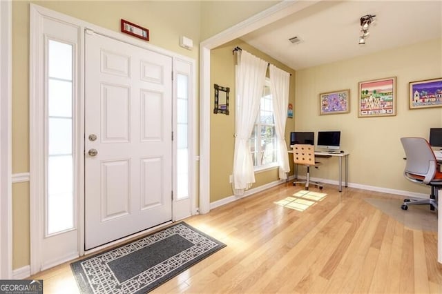 entryway featuring wood finished floors, visible vents, and baseboards