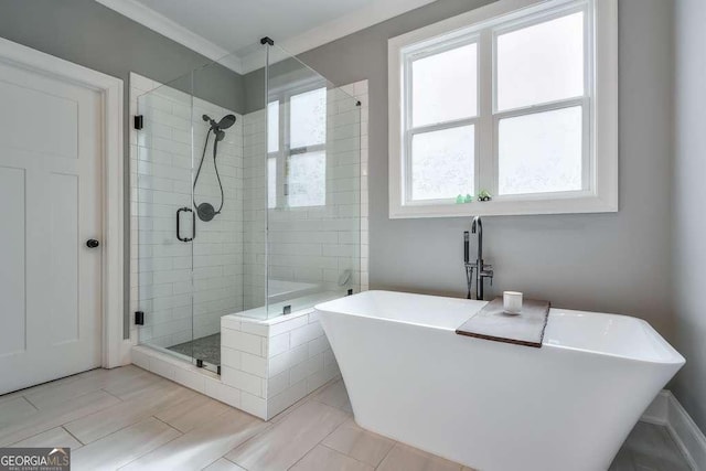 bathroom featuring a soaking tub, a shower stall, and crown molding