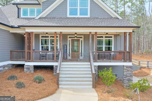 view of front facade featuring a shingled roof, covered porch, and board and batten siding