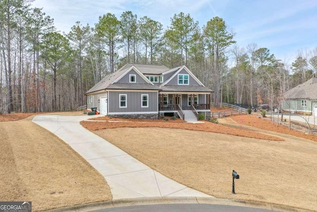 craftsman-style house with driveway, covered porch, board and batten siding, and roof with shingles