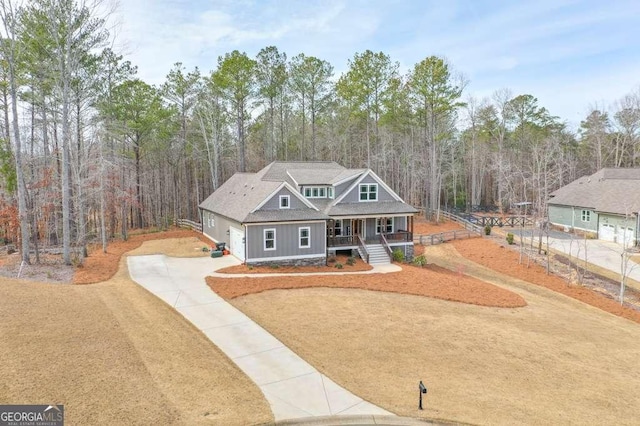 view of front of house with covered porch, concrete driveway, board and batten siding, and a garage