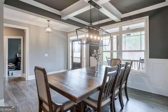 dining space with coffered ceiling, wood finished floors, beam ceiling, and a decorative wall