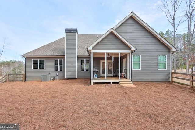 back of property featuring a chimney, a shingled roof, central AC, ceiling fan, and fence private yard