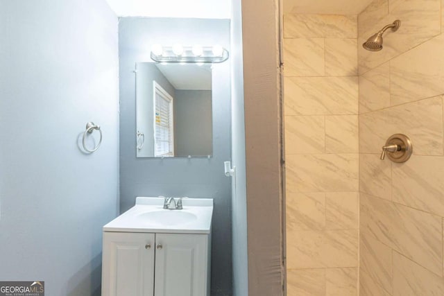 bathroom featuring a tile shower and vanity