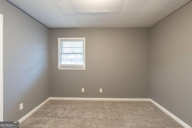 spare room featuring carpet floors and baseboards