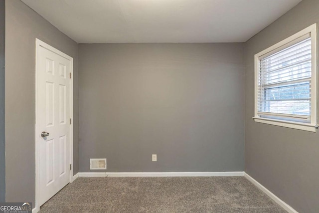 carpeted empty room with visible vents and baseboards