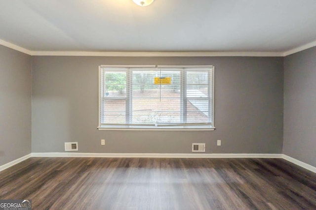 unfurnished room featuring baseboards, crown molding, visible vents, and dark wood-type flooring