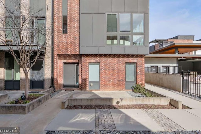 exterior space with fence and brick siding