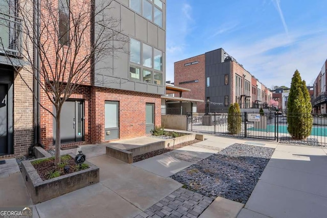 view of home's community with a swimming pool, fence, and a patio