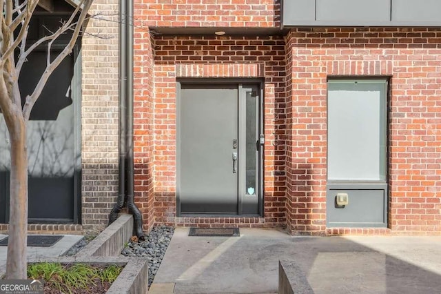 property entrance featuring brick siding