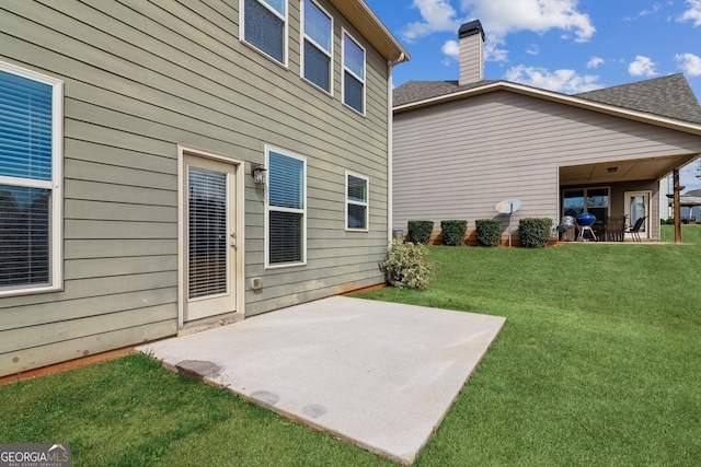 back of house with a patio area and a yard