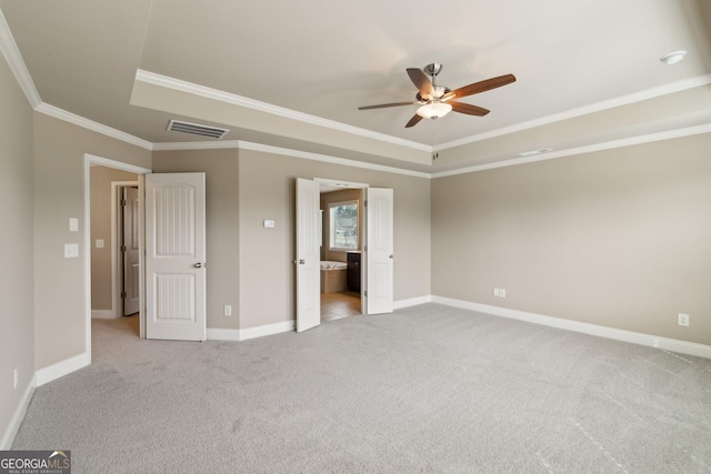 unfurnished bedroom with light carpet, baseboards, visible vents, and a tray ceiling