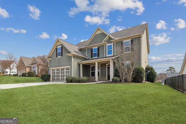 craftsman inspired home with board and batten siding, concrete driveway, fence, and a front lawn