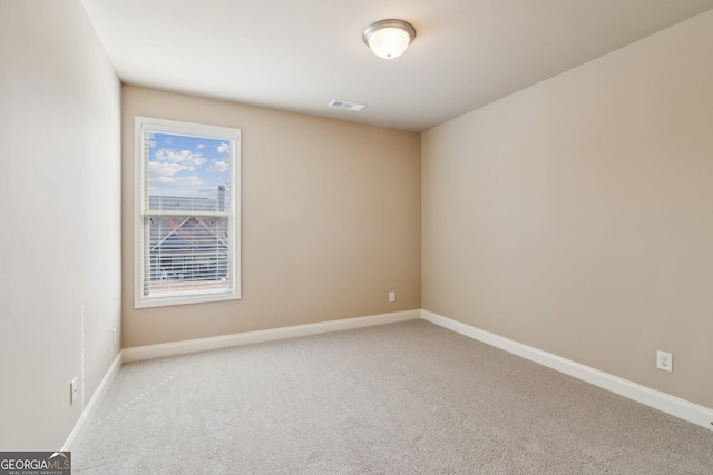 unfurnished room with light carpet, visible vents, and baseboards