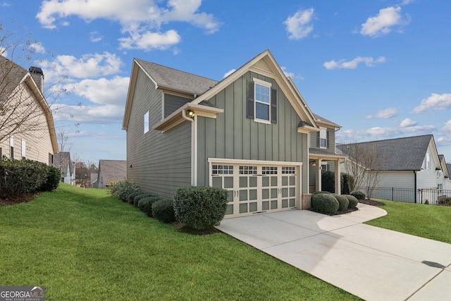 traditional-style home with an attached garage, fence, driveway, a front lawn, and board and batten siding