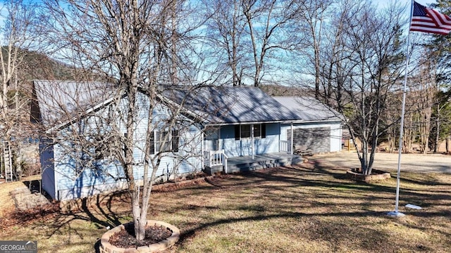 view of front of home featuring metal roof and a front lawn