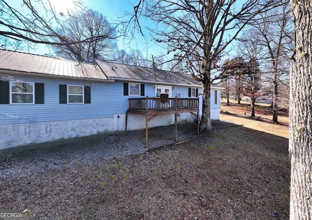 back of property with a deck and metal roof