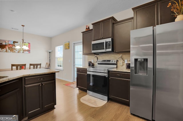 152 Summerhill Dr NE, Ludowici, GA 31316 - kitchen with dark brown cabinetry, backsplash, stainless steel appliances, and light wood finished floors