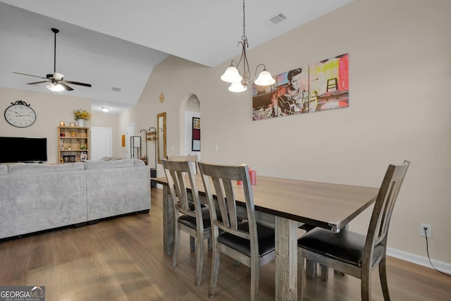 152 Summerhill Dr NE, Ludowici, GA 31316 - dining room with arched walkways, dark wood finished floors, visible vents, vaulted ceiling, and ceiling fan with notable chandelier