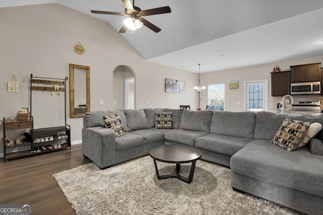 152 Summerhill Dr NE, Ludowici, GA 31316 - living area featuring high vaulted ceiling, arched walkways, dark wood-style flooring, and ceiling fan with notable chandelier