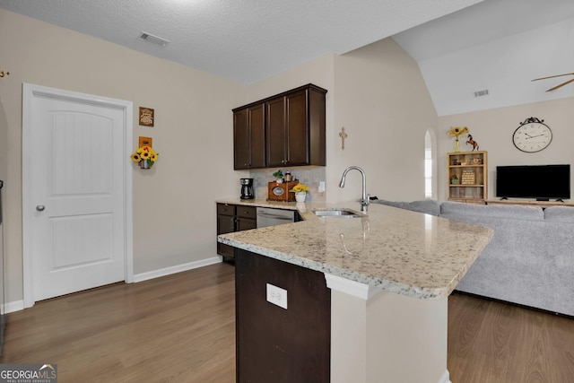 152 Summerhill Dr NE, Ludowici, GA 31316 - kitchen featuring arched walkways, dark brown cabinetry, wood finished floors, a sink, and open floor plan