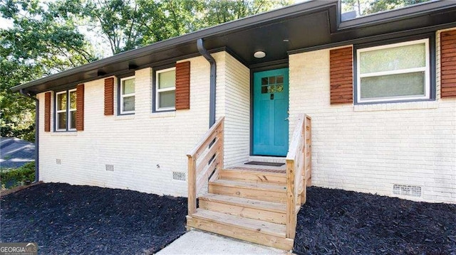 property entrance with crawl space and brick siding