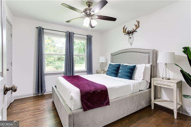 bedroom featuring baseboards, dark wood finished floors, and a ceiling fan