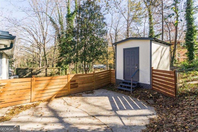 view of outbuilding featuring entry steps and fence