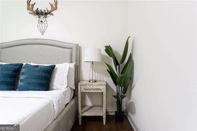 bedroom featuring dark wood-type flooring and baseboards