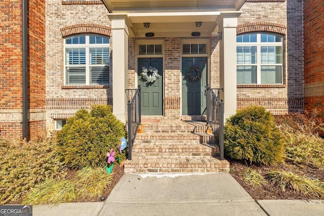 view of exterior entry featuring brick siding