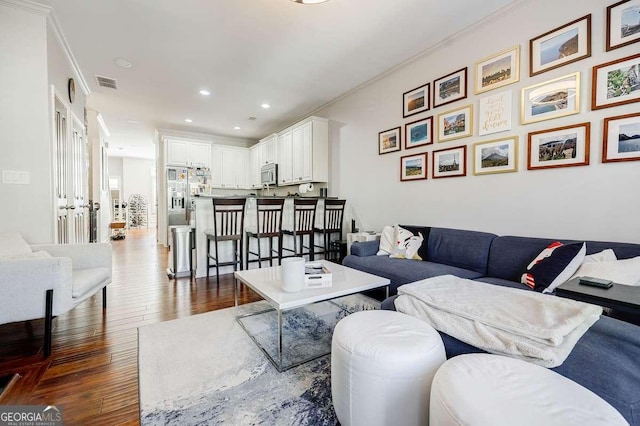 living room with dark wood-type flooring, recessed lighting, visible vents, and crown molding